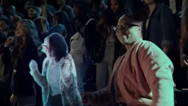 A woman appears as a photorealistic hologram at a concert, demonstrating the metaverse's vision of instant teleportation.