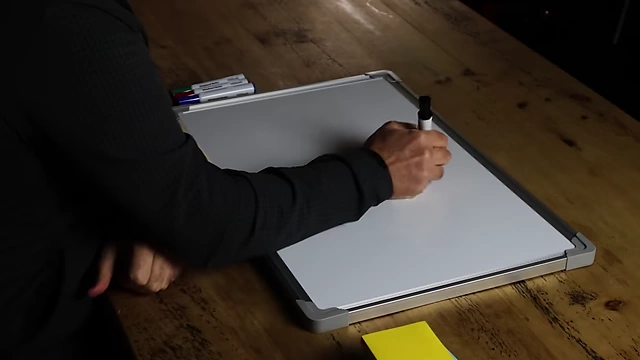 The speaker writing "delayed gratification" on a whiteboard.