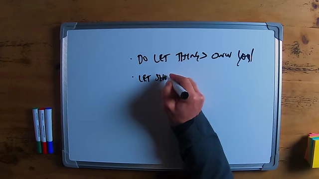The speaker writing "let short-term ego go" on a whiteboard.
