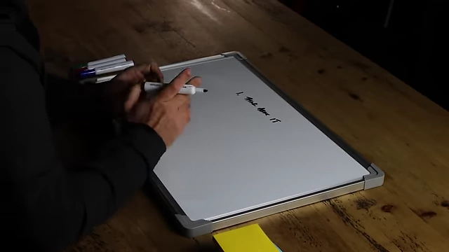 The speaker writing "Think about it" on a whiteboard as the first step to finding purpose.