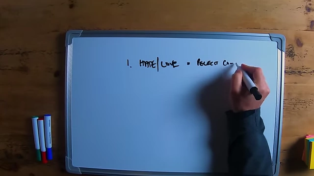 The speaker writing "hate | love = perfect co-founder" on a whiteboard.