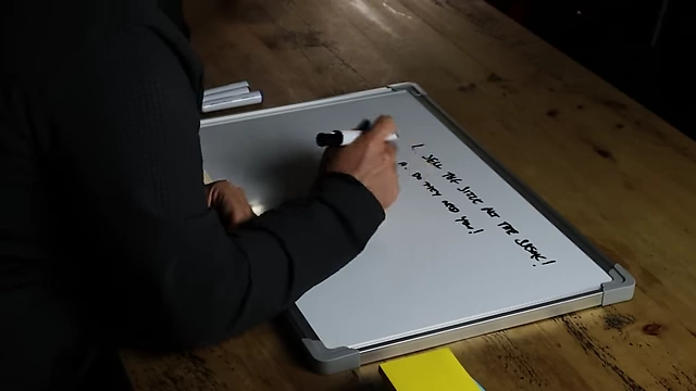 The speaker writing "do you like them?" on a whiteboard as the second step in selling.