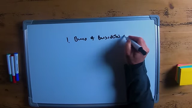The speaker writing "Build a business you love" as the first step for selling a business successfully.