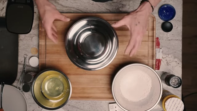A kitchen setup showing bowls for dry mix, egg wash, and crushed Rice Krispies for breading