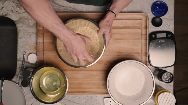 Crushing puffed rice cereal with a glass tumbler in a bowl