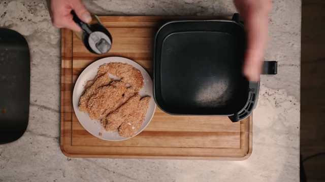 Lightly spraying the air fryer basket with olive oil