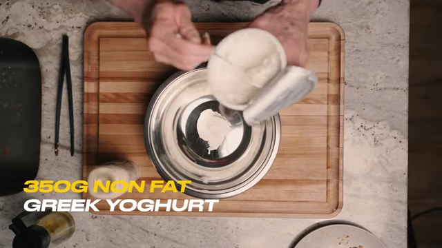 Adding non-fat Greek yogurt to a mixing bowl for the sauce