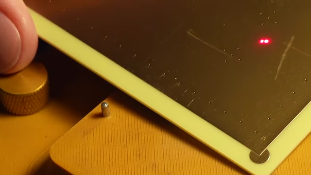Laser light illuminating the exposed fiberglass alignment features on the PCB