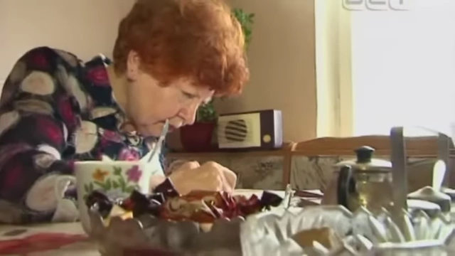 An elderly woman listening to a wired radio, representing the enduring audience after its decline.