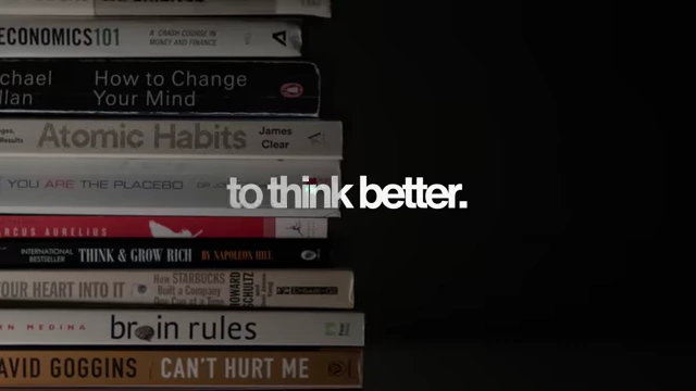 A stack of self-improvement books, including "Atomic Habits"