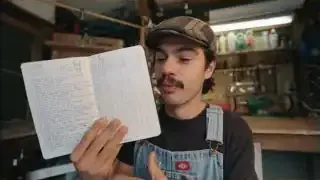 The speaker proudly displays his habit tracker journal, showcasing his consistent daily entries.
