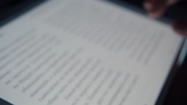 Hand scrolling through a book on a Kindle e-reader