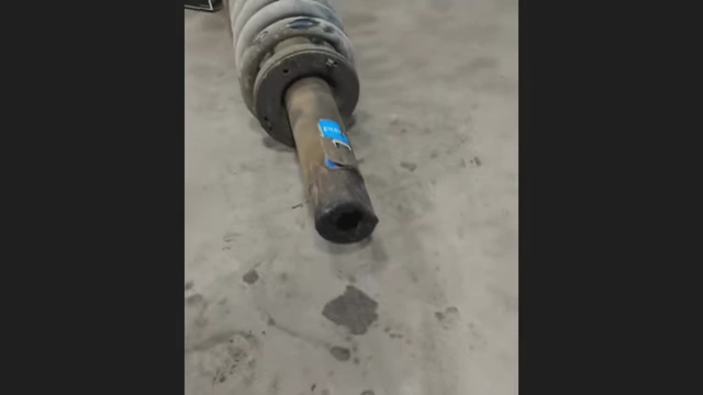 A shock absorber that has completely sheared off its bottom section.