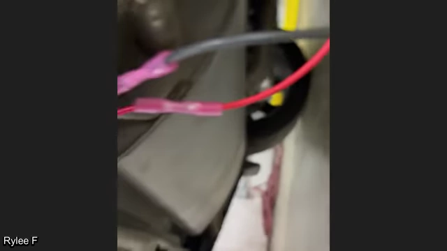 Exposed, poorly connected wiring for an aftermarket backup alarm installation in a vehicle.