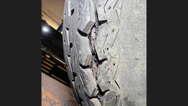 Close-up of a tire with severe cracks and exposed cords, indicating extreme age and wear.