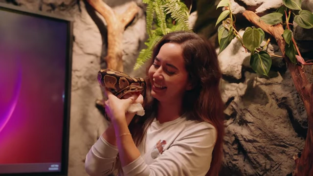 Maya Higa gently holding a snake, demonstrating ethical and caring interaction.