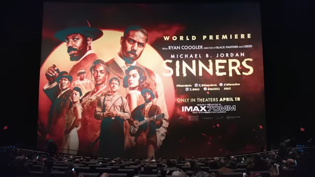 Ryan Coogler's Sinners promotional poster displayed in an IMAX theater, highlighting its grand cinematic scale.