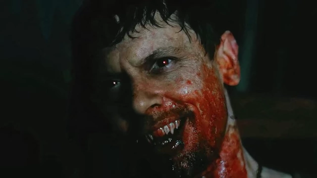 A vampire with bloodied face and fangs from "Sinners," representing the film's sinister metaphor.