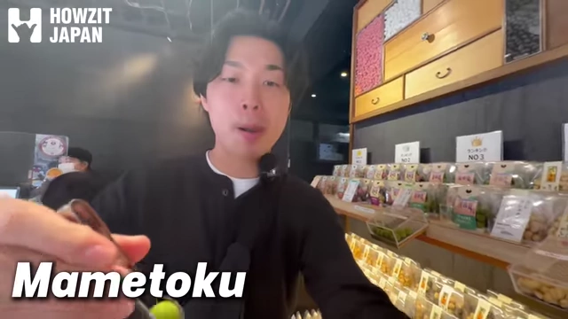 Speaker holding a bean snack from Mametoku