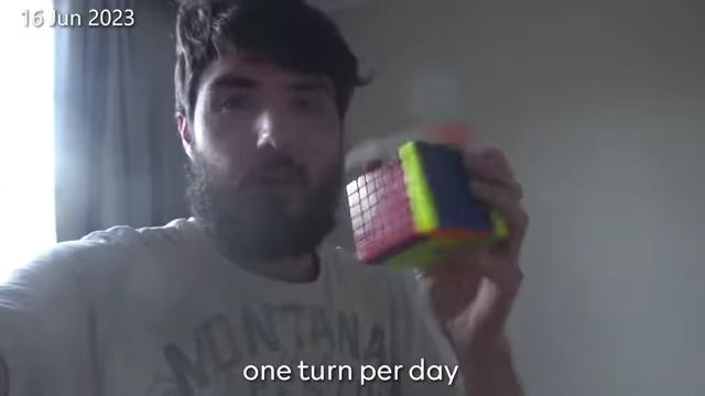 The creator holds a 7x7 Rubik's cube, one of his long-term video projects.