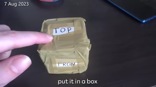 The scrambled Rubik's cube is carefully labeled and put in a box.