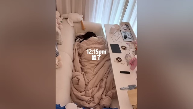 A person wakes up at 12:15 PM, embodying the 'bed rotting' lifestyle.