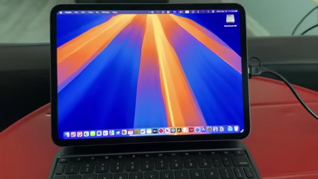 The iPad Pro displaying the macOS desktop from the Mac Mini via an HDMI capture card, connected to the side.