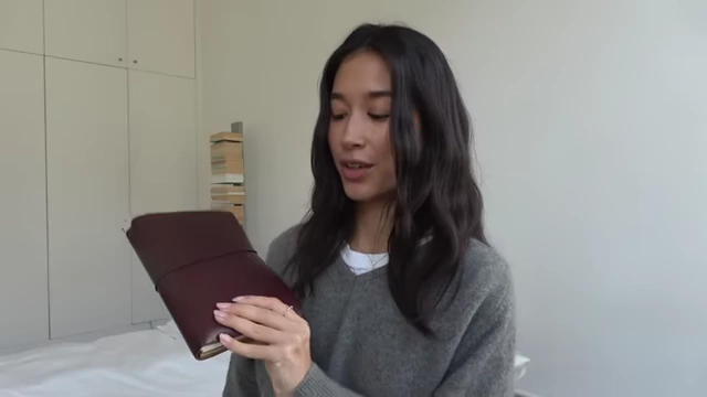 The presenter holds up the closed Paper Republic Grand Voyageur leather portfolio.
