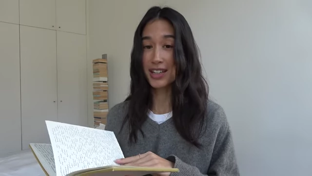 The presenter holds her personal journal open, displaying handwritten content.