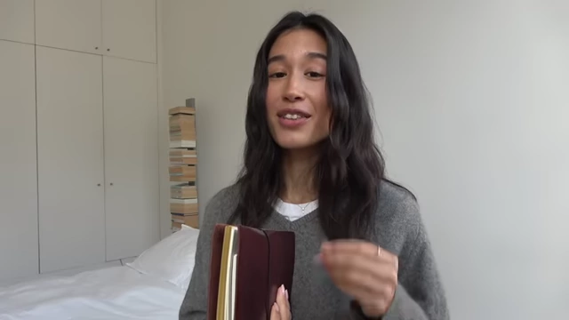A collection of various notebooks and a pen, showcasing the presenter's diverse journaling system.