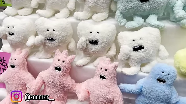 Unique, pastel-colored plush monster toys on display.