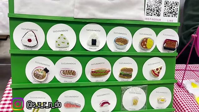 A display of miniature food pins and magnets, featuring various Japanese dishes.