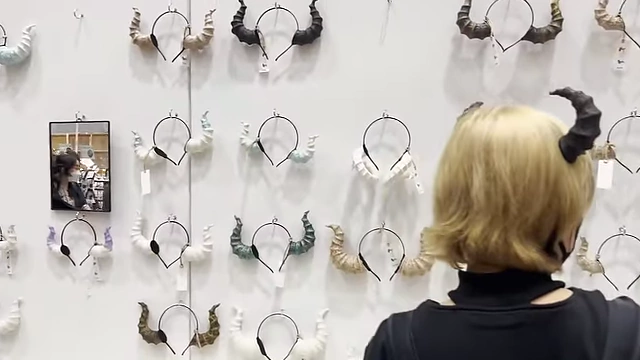 A wall display featuring a variety of unique horn headbands in different shapes and colors.