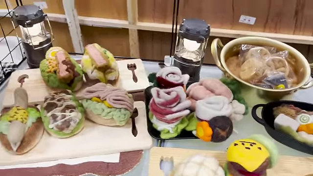 Soft felt food art pieces, resembling sandwiches and elaborate floral arrangements.