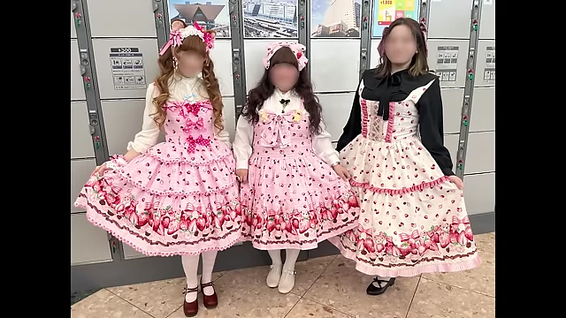 Three friends showcasing their coordinated strawberry-themed Lolita fashion outfits.