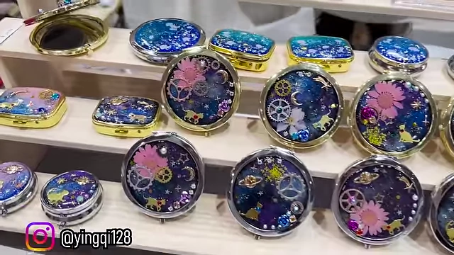 Ornate compact mirrors and trinkets, featuring celestial and floral designs.
