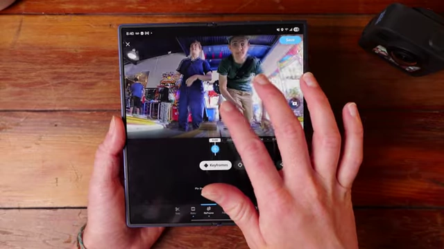 Hands editing a 360 video in the GoPro Quik app on a folding phone