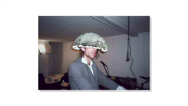 A photo by Ivan Zhao featuring a person wearing a disco ball helmet, reflecting his artistic background.