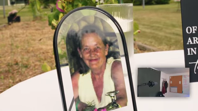 A framed picture of a smiling elderly woman with a drink.