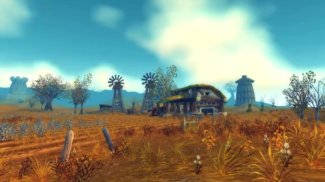 A scenic view of Westfall from World of Warcraft, featuring windmills and farmland.