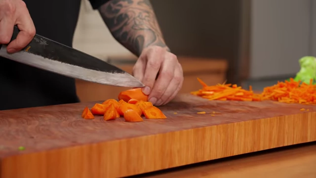 A chef demonstrates how to cut carrots into varied, rustic shapes ideal for roasting by slicing and rotating the carrot