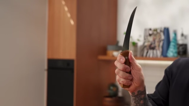 A close-up of a hand properly gripping the handle of a boning knife