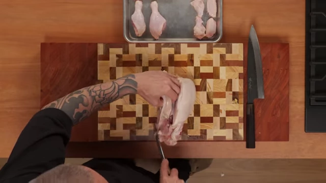 An overhead shot of the chef carefully removing a chicken breast from the carcass