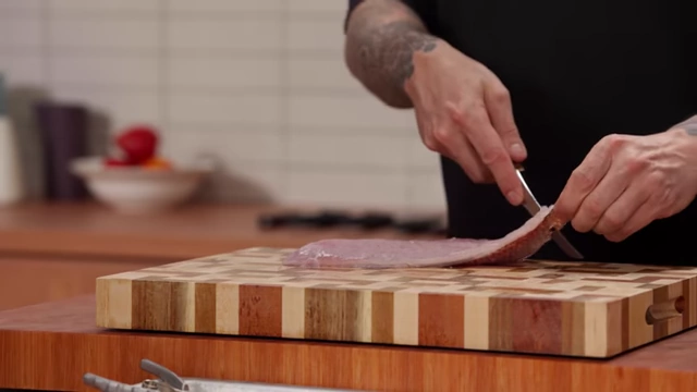 A chef shows a small incision in the fish skin to get a better grip for skinning