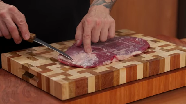 A chef points out the silver skin on a raw piece of beef