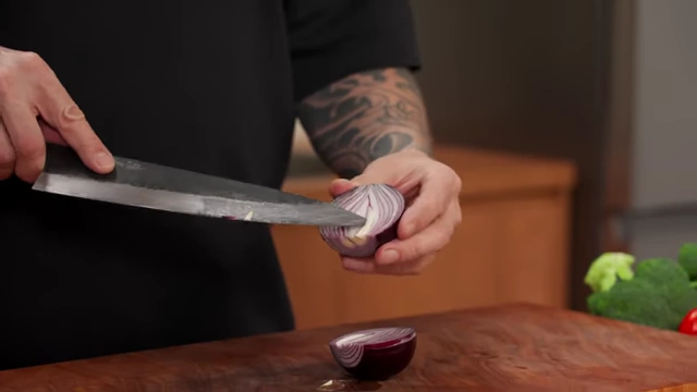 A chef shows how the grain of an onion runs from top to root, guiding the slicing direction