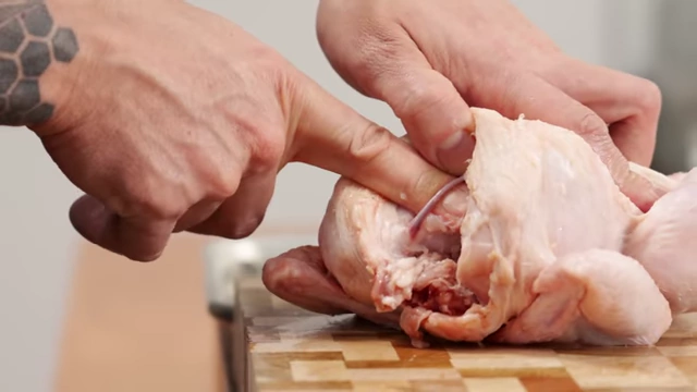 A chef loosens the wishbone with his fingers before pulling it out of the chicken