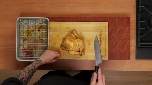 An overhead view of a roasted chicken on a cutting board with twine, ready for carving