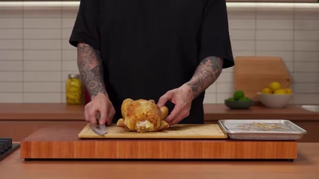 A chef pops the leg joint of a roasted chicken to prepare for removal
