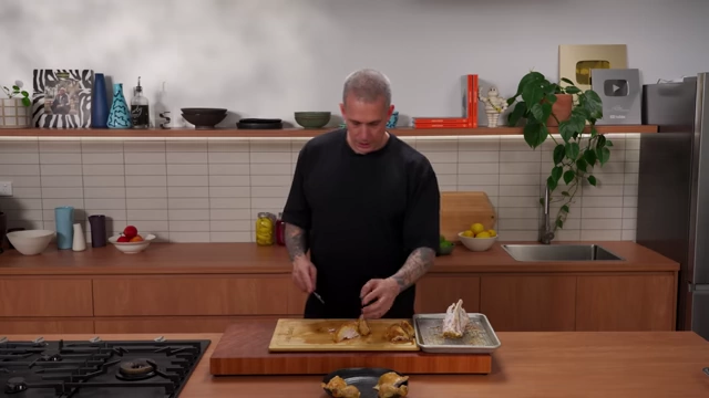 A chef slices roasted chicken breast into individual portions